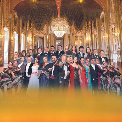 Zu sehen sind die Musiker und Musikerinnen, Sänger und Sängerinnen sowie die Tänzer und Tänzerinnen.